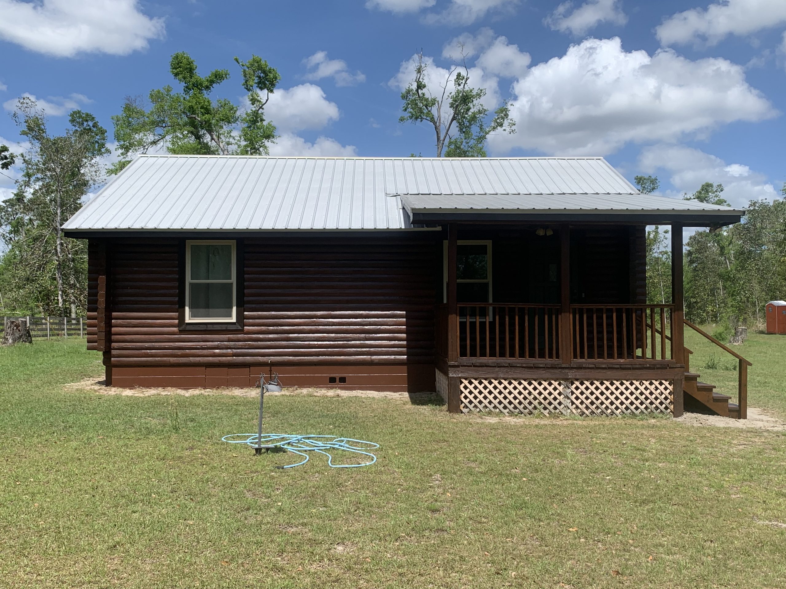 05-log-cabin-restoration-live-oak-fl-front-exterior-after After restoration: front exterior of a log cabin freshly restained dark brown in Live Oak, FL