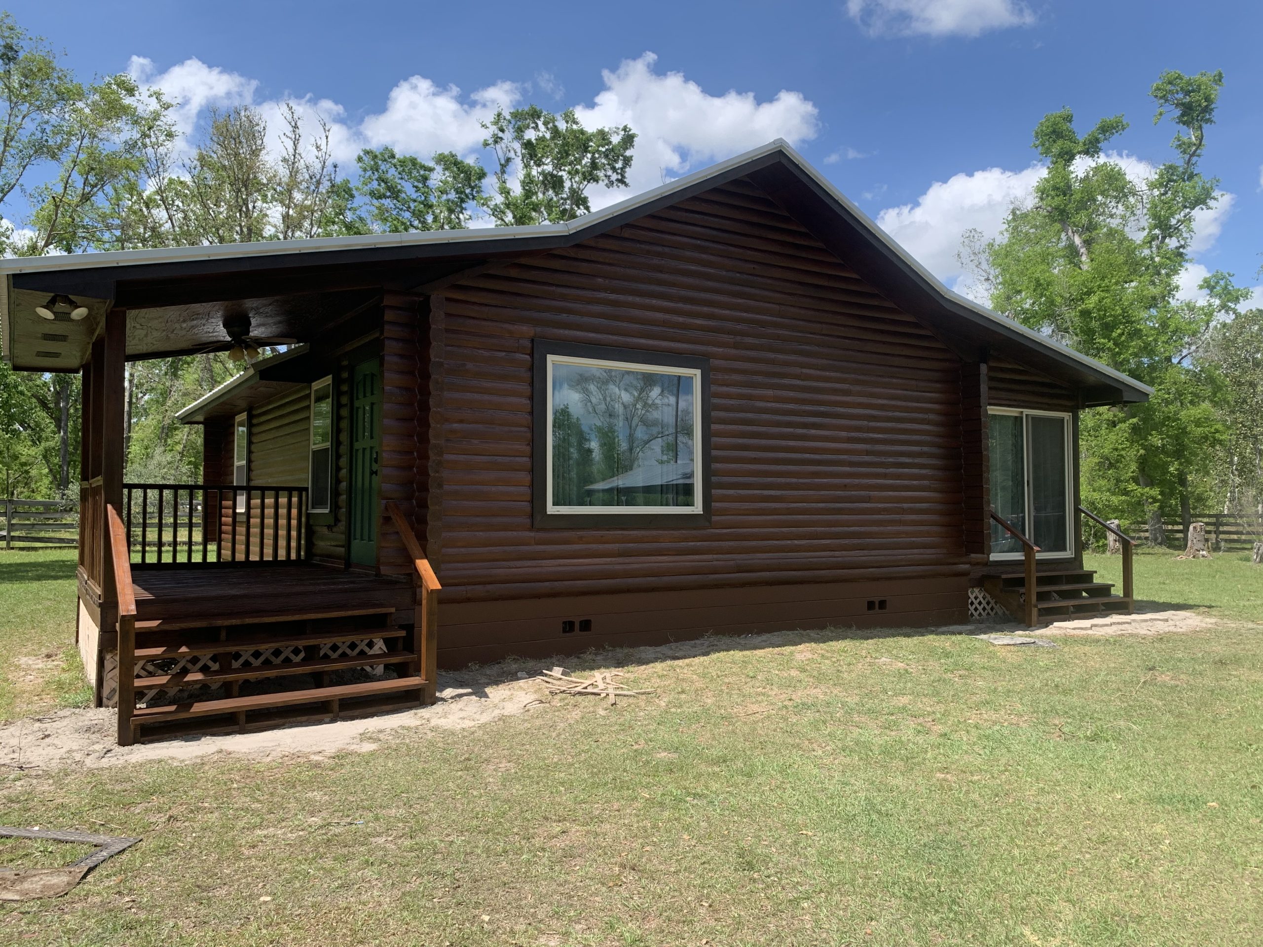 07-log-cabin-restoration-live-oak-fl-porch-entry-after After restoration: porch entry of a log cabin freshly restained dark brown in Live Oak, FL