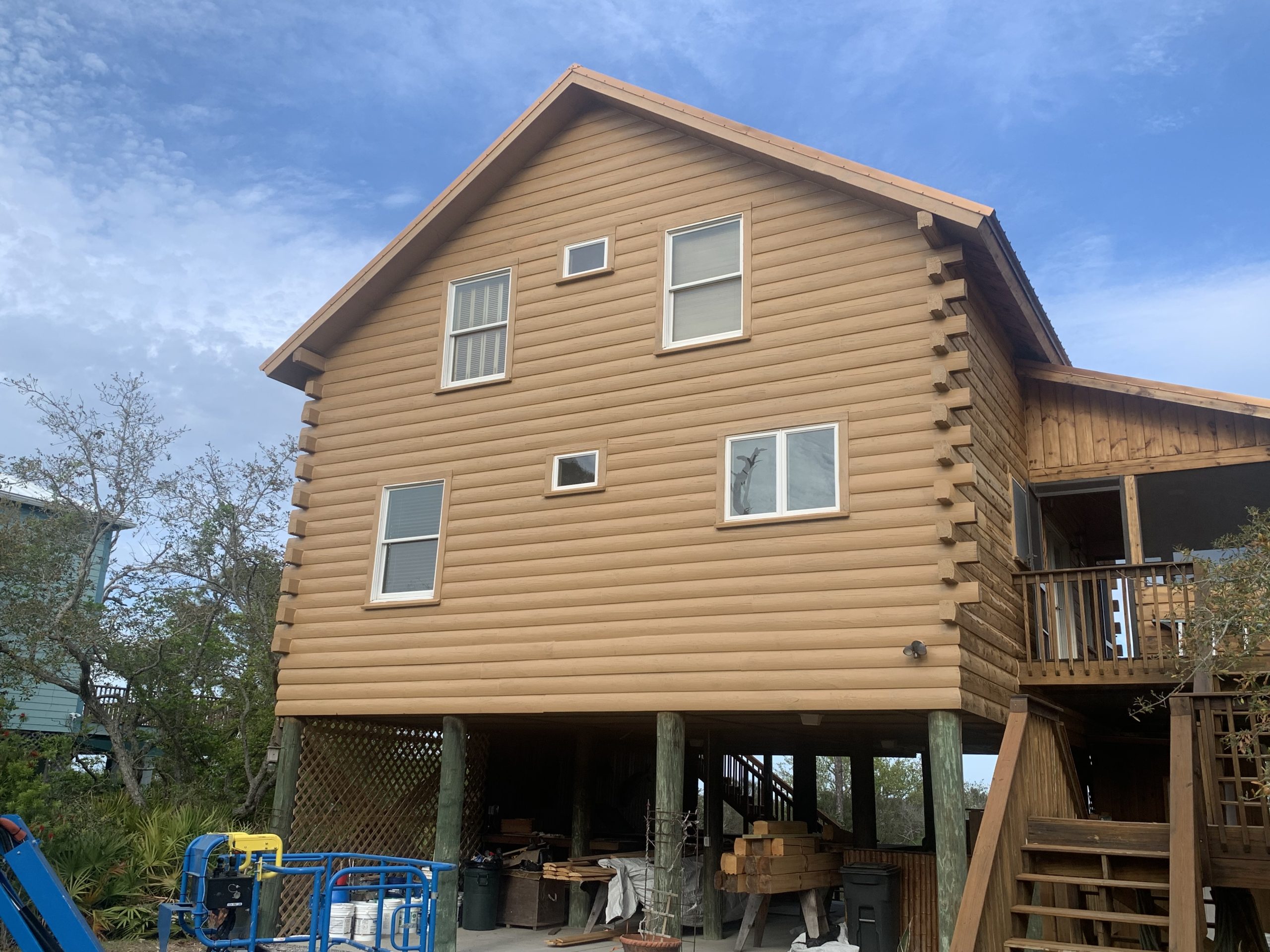 After restaining: elevated log cabin on pilings with a fresh tan stain