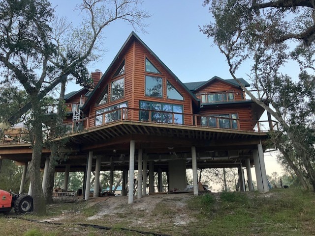 Elevated log home on pilings after exterior restoration and restaining