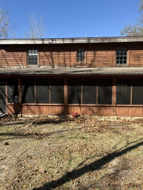 Rear elevation of a log home with a dull, worn exterior finish before restoration