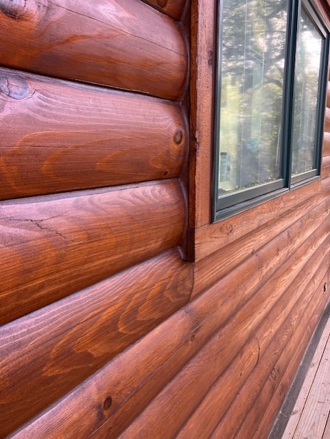 Close-up of energy-sealed log lines and window trim on a finished log wall