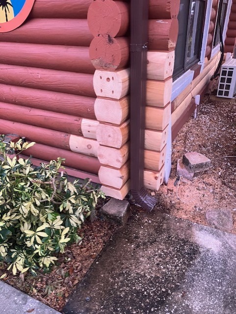 Log end repair at a downspout corner where water had damaged the wood