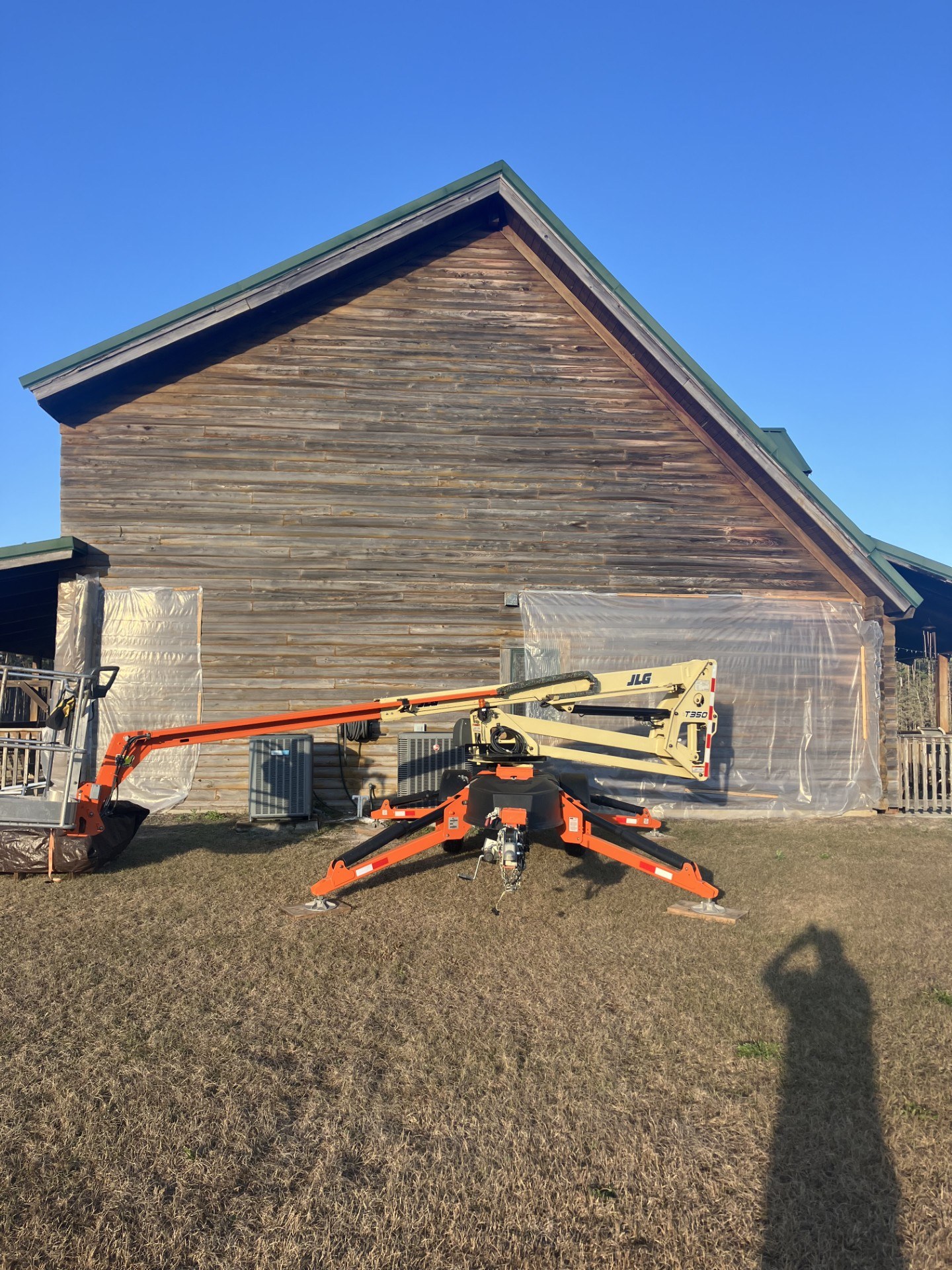 Log home gable stripped to bare wood by media blasting, with plastic masking in place