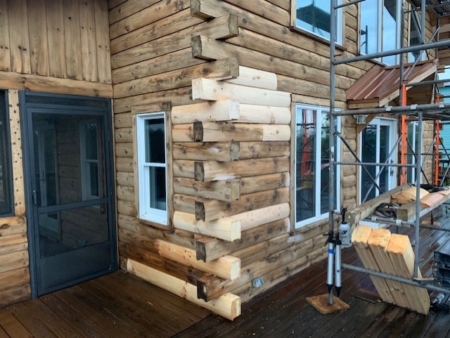 New replacement logs installed at a log home corner, ready for finishing