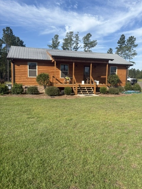 Restored log cabin front elevation with mature landscaping