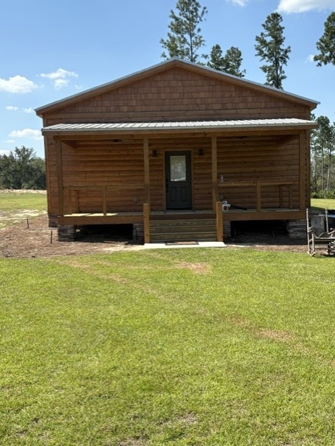 Restored log cabin with a shake-sided gable and covered porch