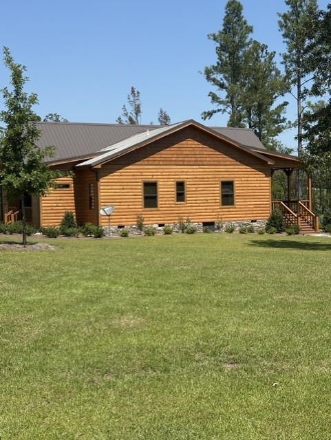 Side elevation of a restored log home with a metal roof