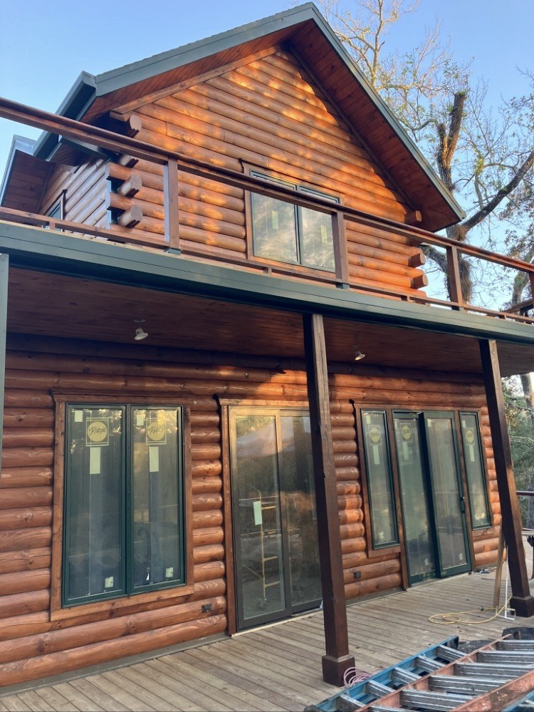 Two-story log home with an upper deck after exterior restoration